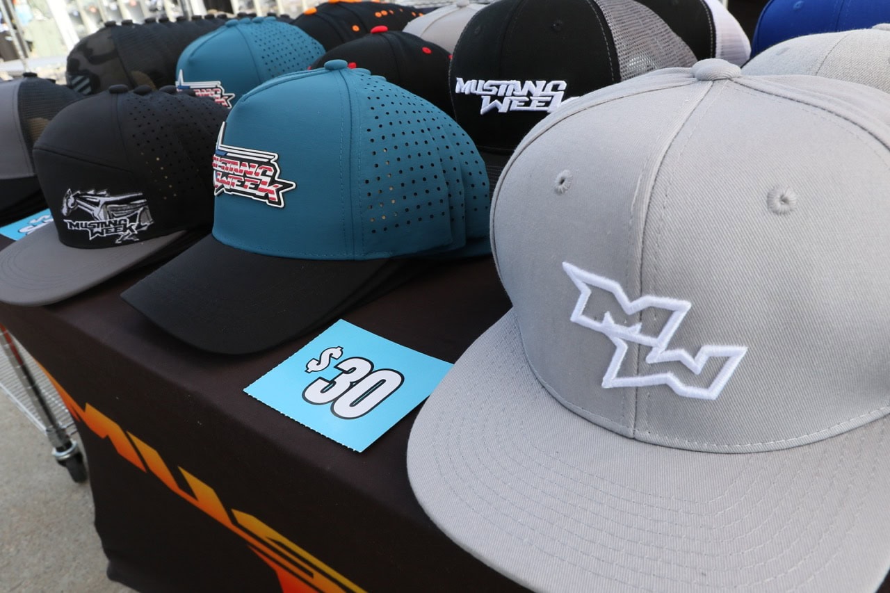 Collection of Mustang Week branded caps and hats at the event.