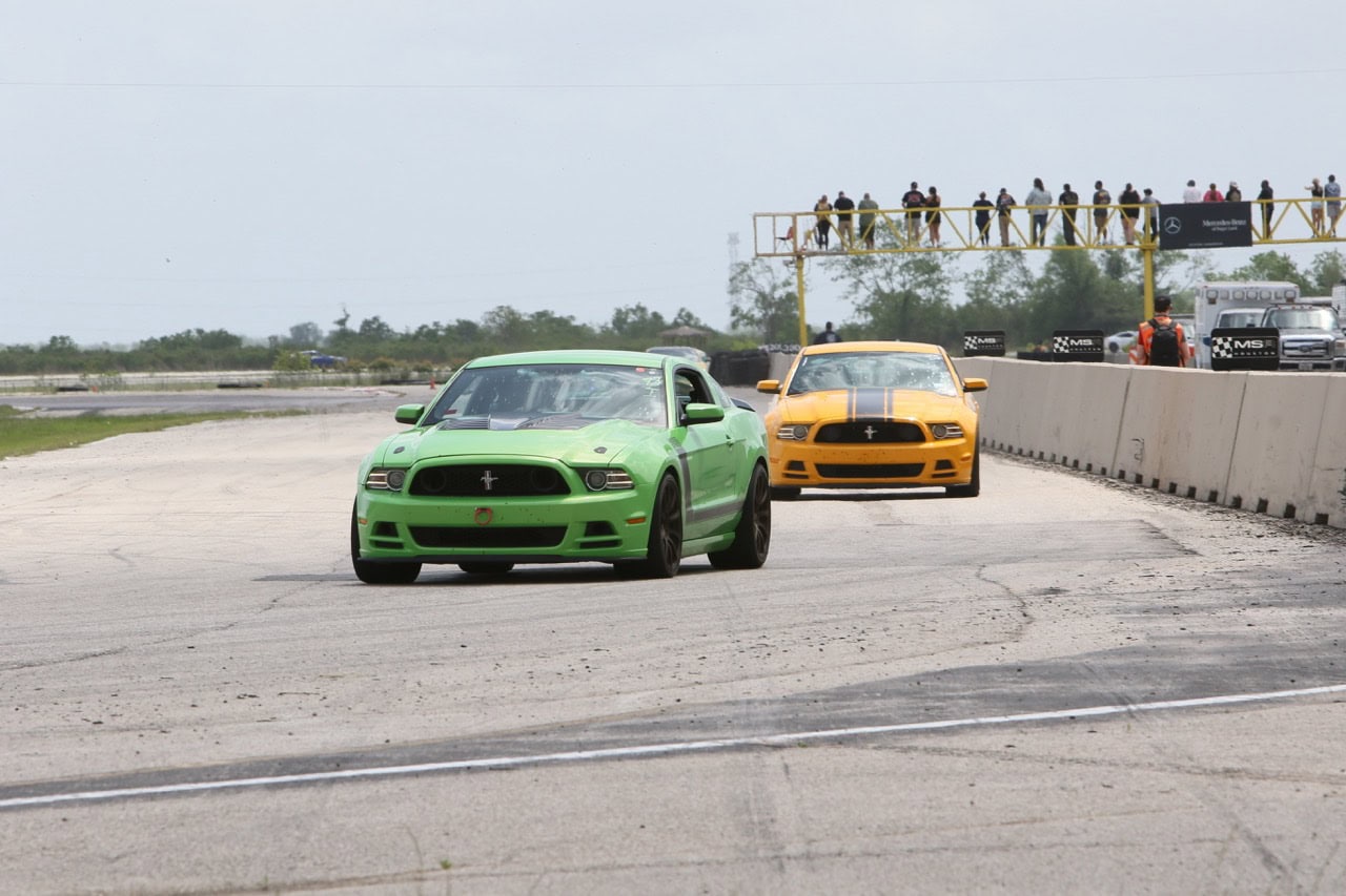Green and yellow Ford Mustangs racing at Mustang Week event in Texas 2026.