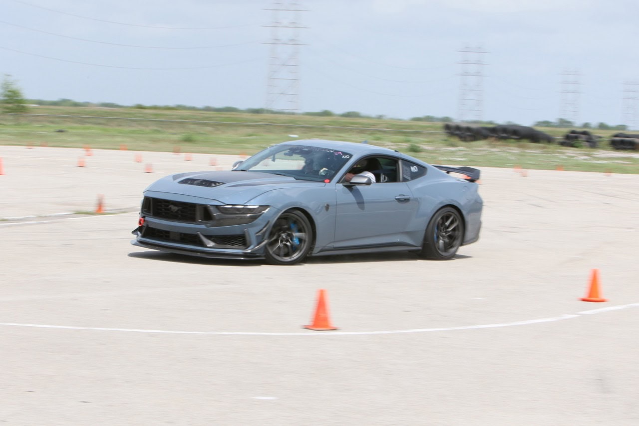 Modern gray Ford Mustang racing through an autocross course at Mustang Week.