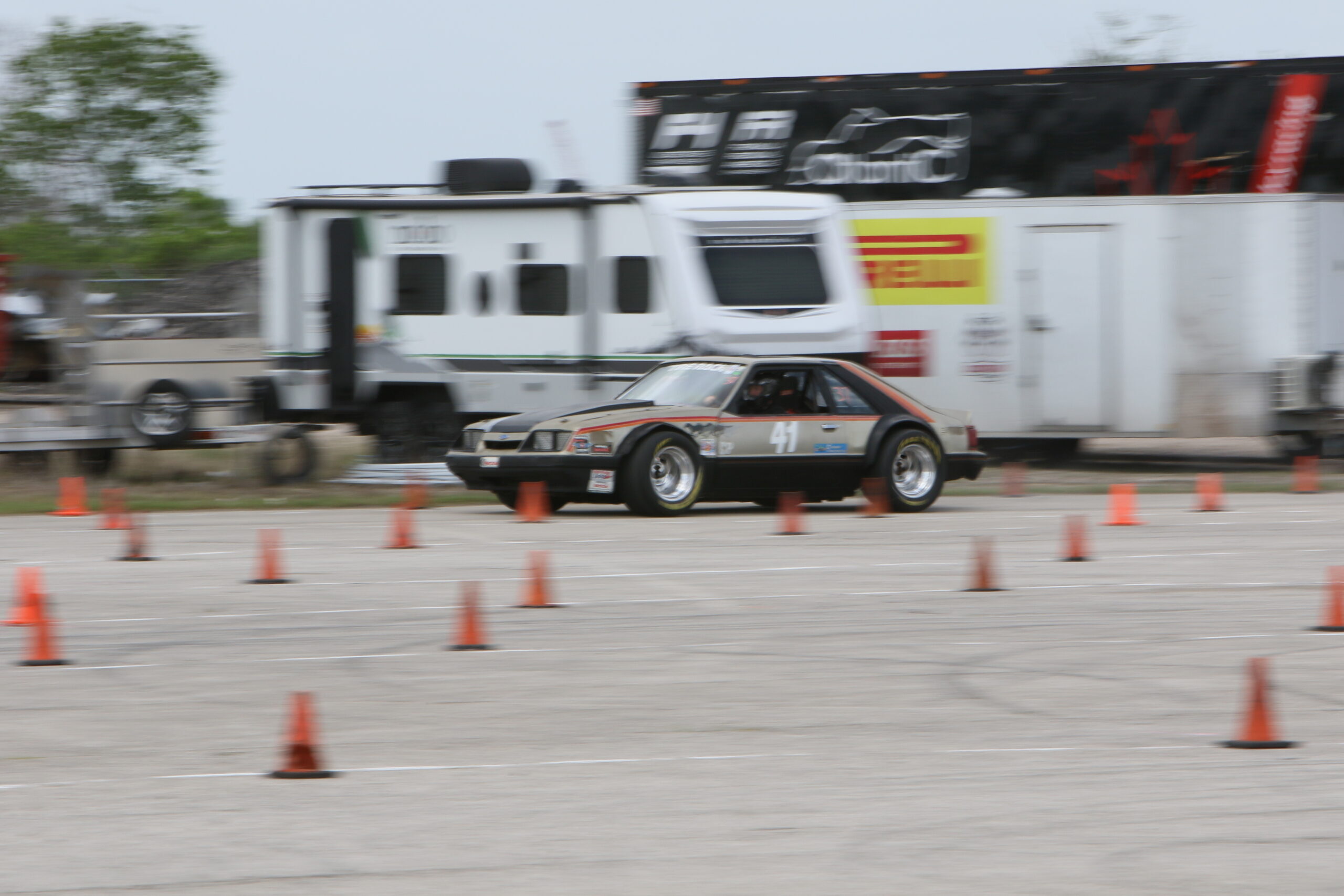 Mustang Week racing event with classic Ford Mustang on track.