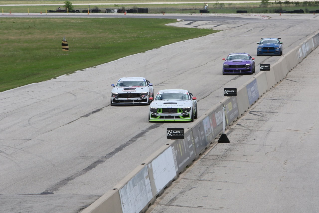 Mustang race cars on track at Mustang Week event.