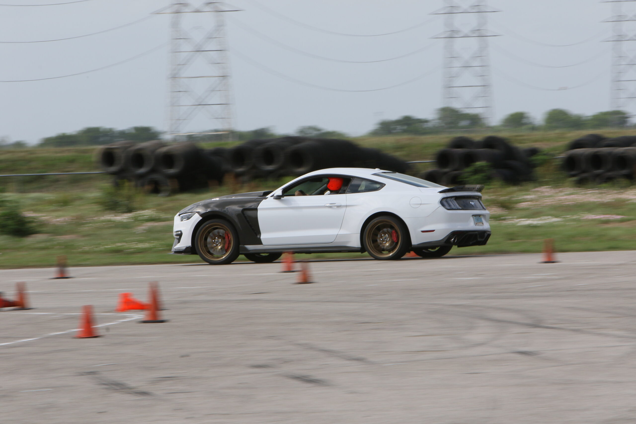 White Ford Mustang racing on track during Mustang Week event.