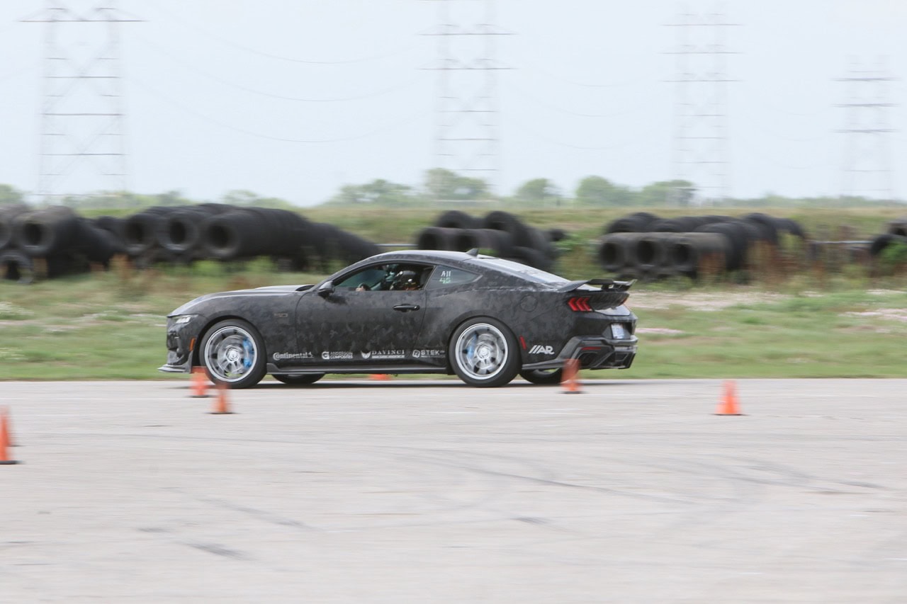 High-performance Mustang driving through an autocross course at Mustang Week.