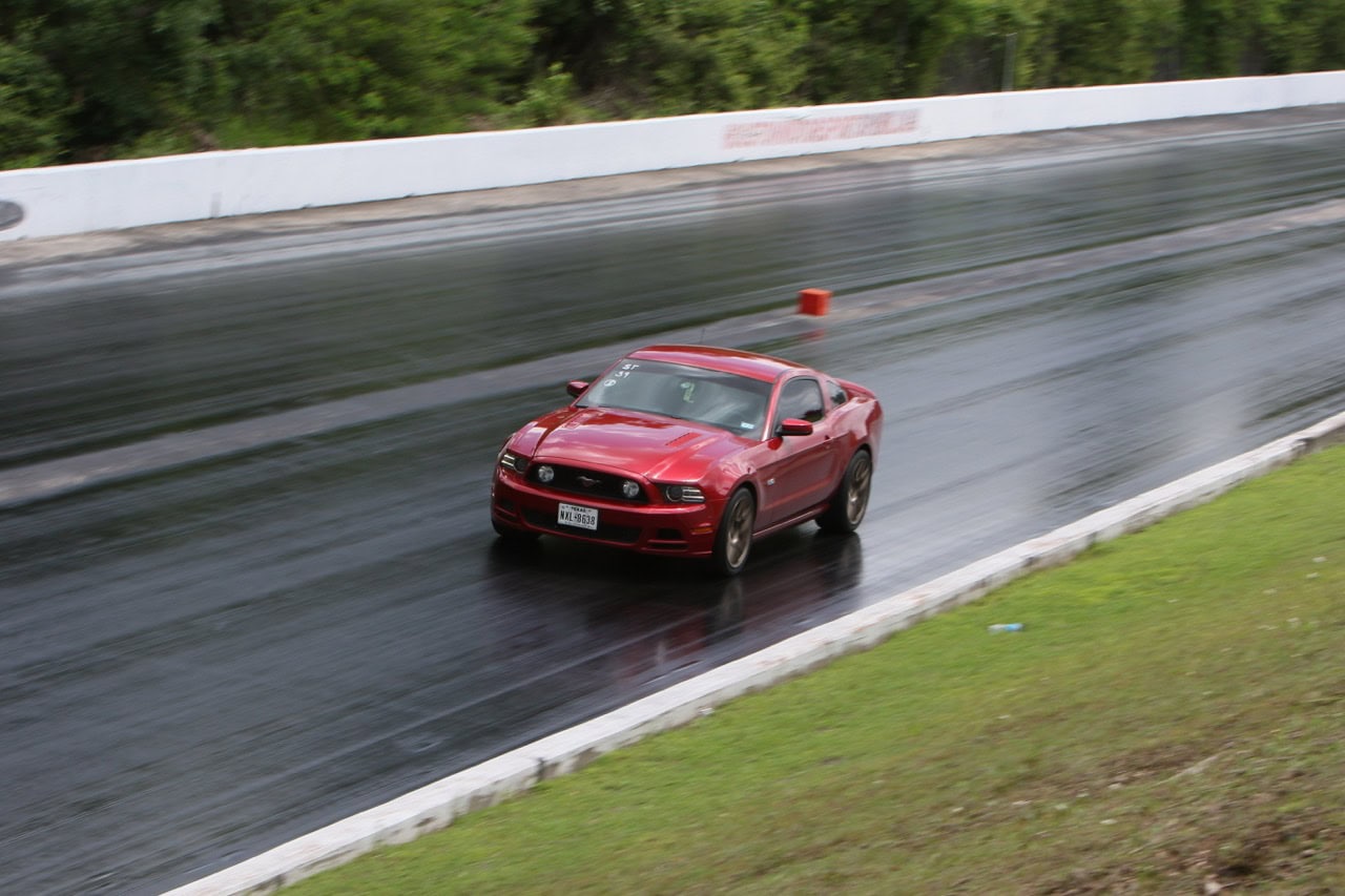 High-speed Mustang racing at Texas drag strip.