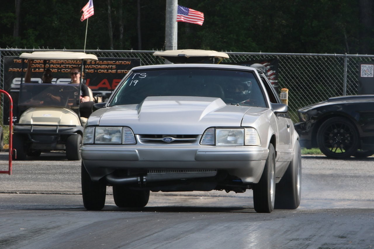 Classic silver Mustang drag racing car at Mustang Week event.