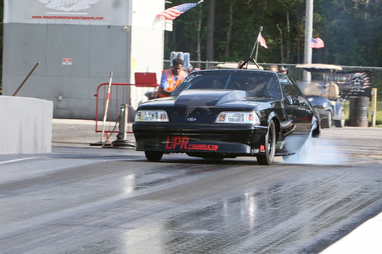 High-speed Mustang drag racing at Mustang Week event.