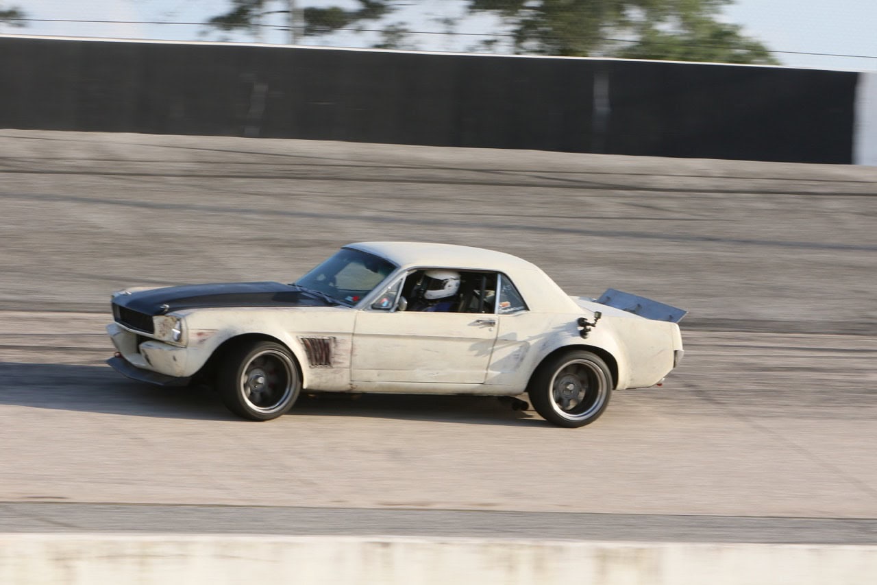 Classic Ford Mustang racing at Mustang Week event.