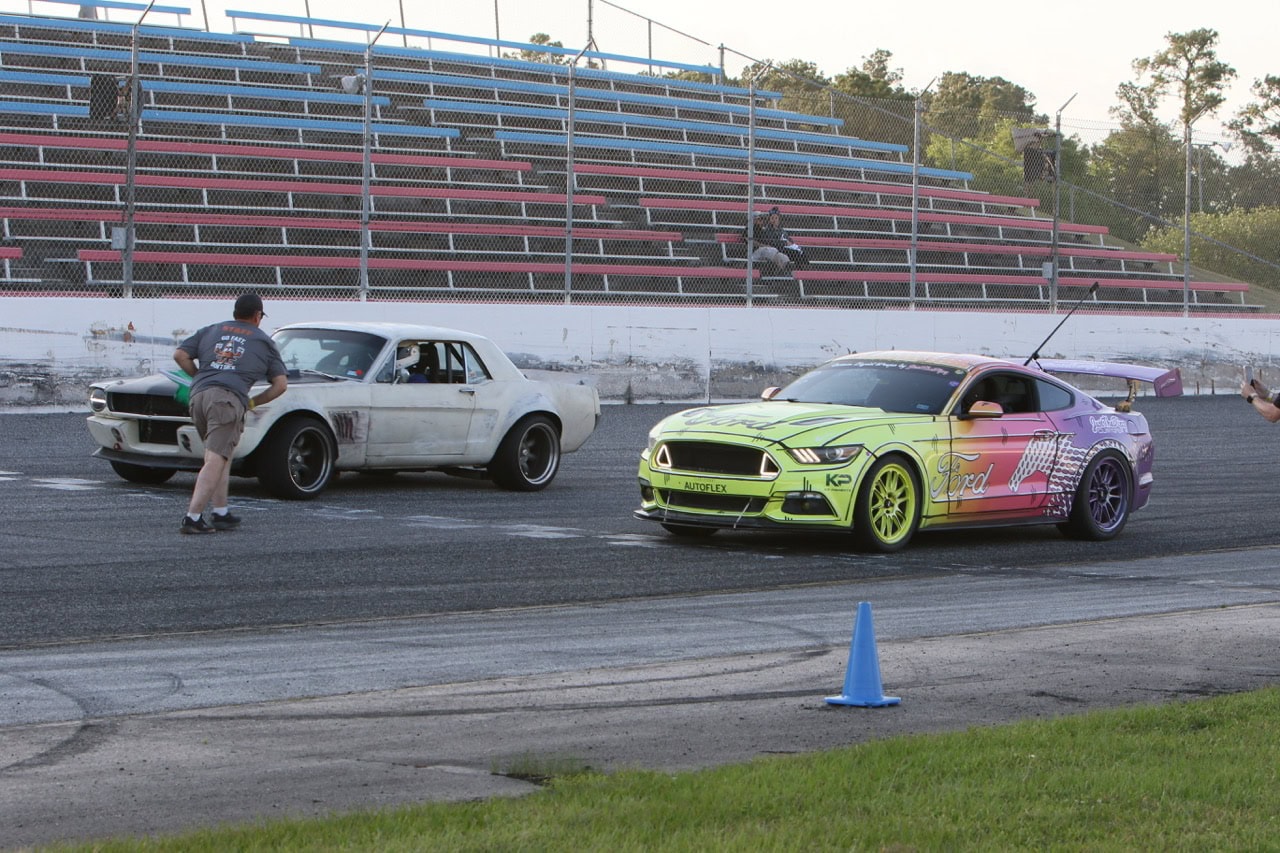 Mustang Week drag race with colorful and classic Ford Mustangs on the track.