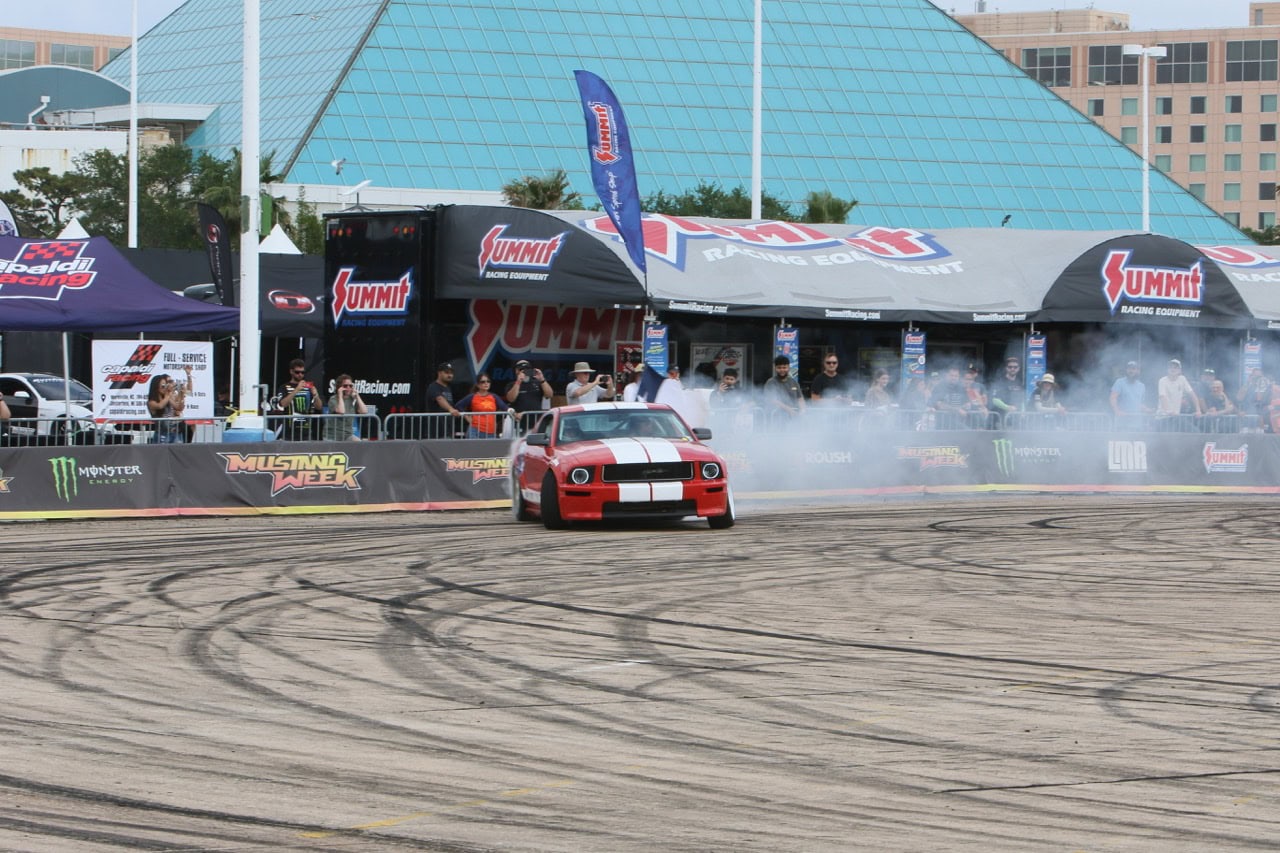 Mustang car performing a drift at Mustang Week event.