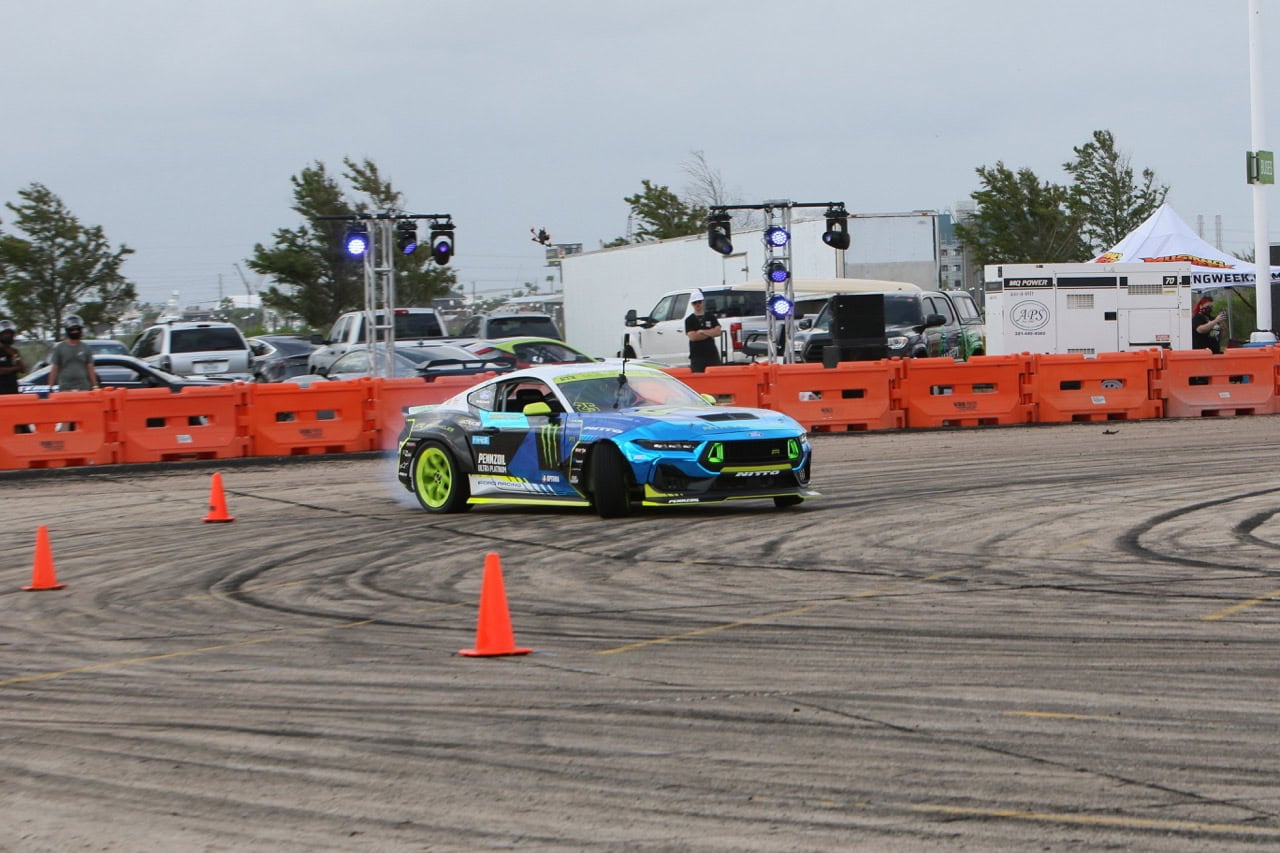 Mustang Week drift car performing stunt at event.