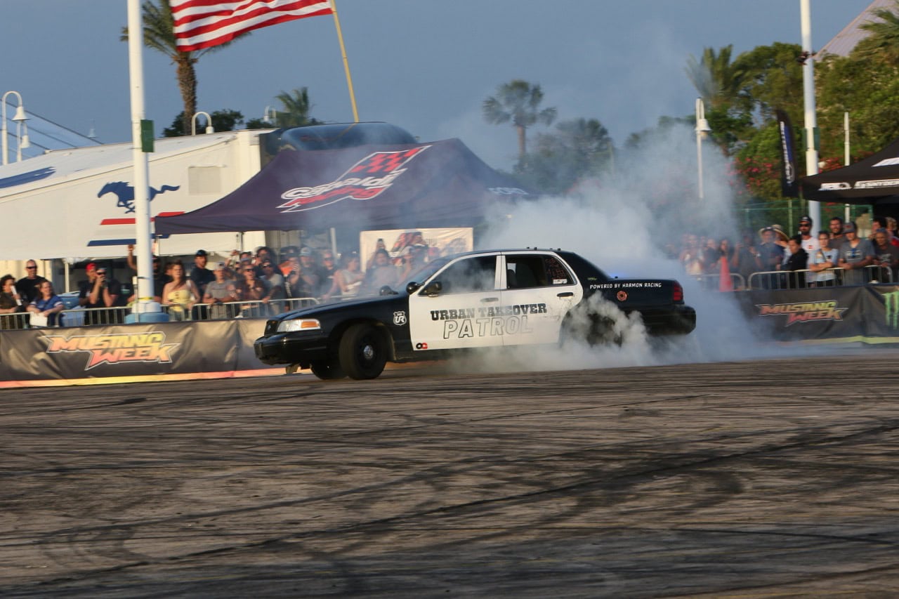 Mustang drag racing car performing burnout at Mustang Week event.