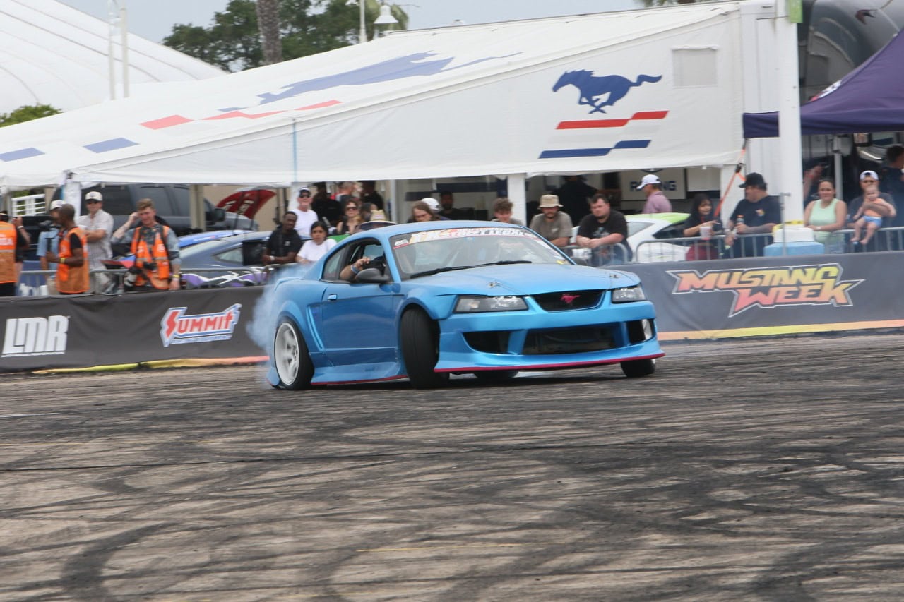 Blue Mustang drift car performing at Mustang Week event.