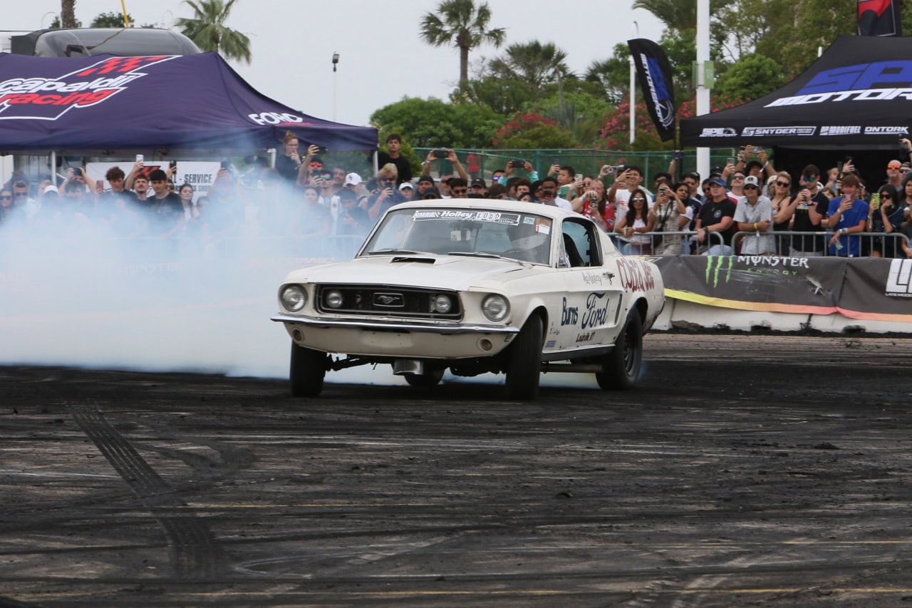 Classic Ford Mustang performing a burnout at Mustang Week event.