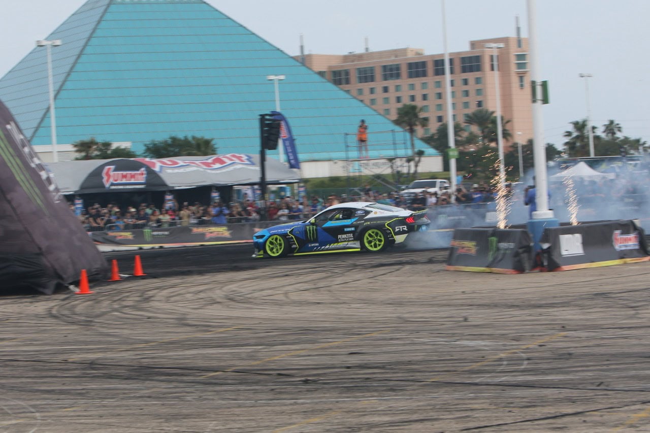 Mustang Week drift car performing stunts at a motorsport event.