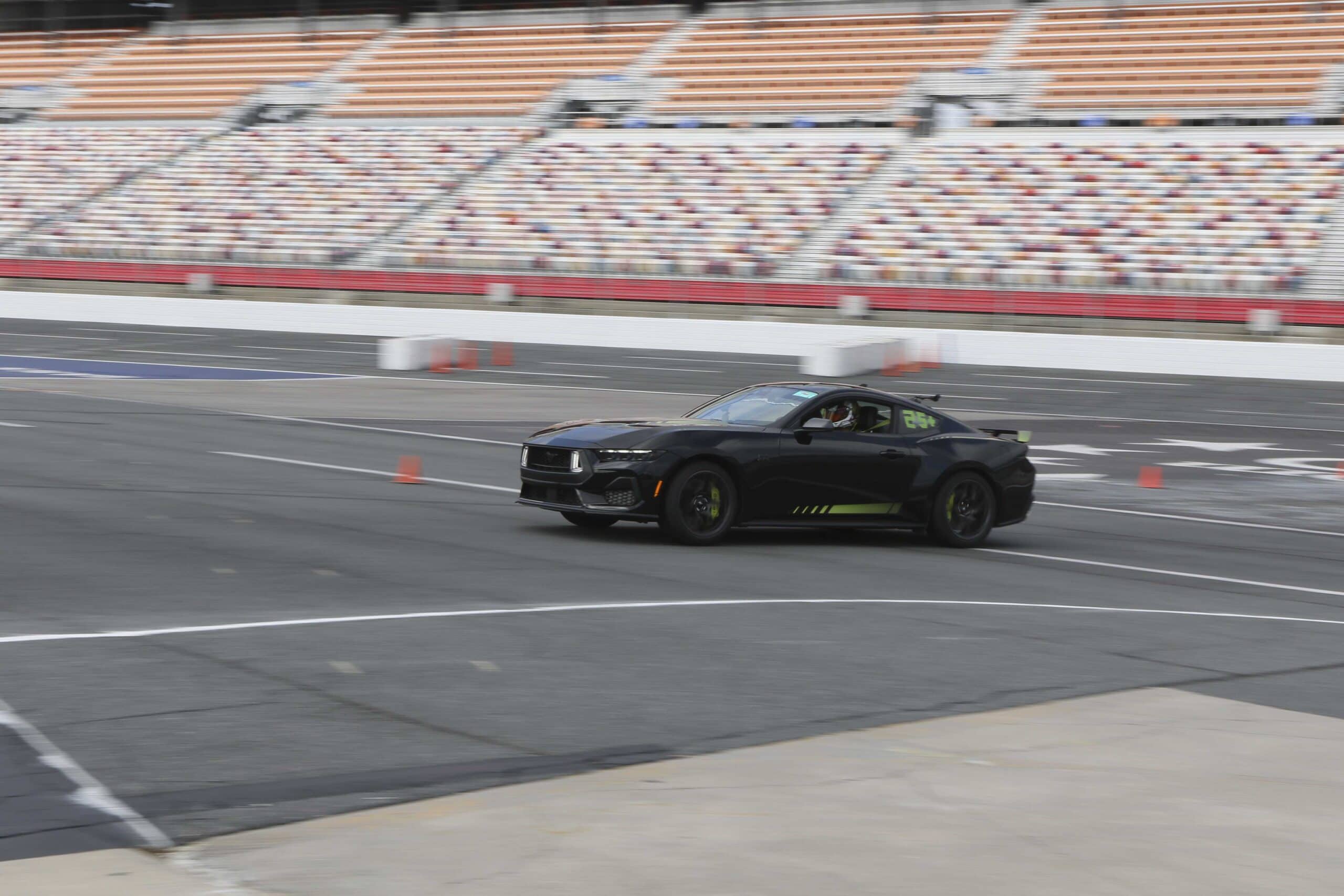 Black Ford Mustang on race track during Mustang Week event.