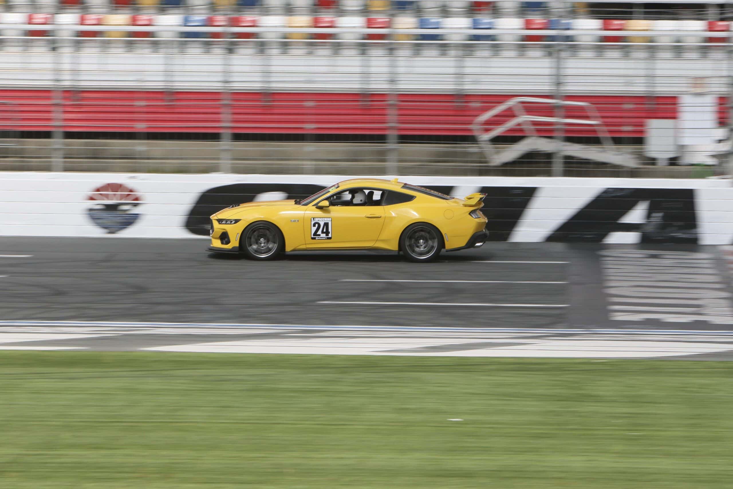 Yellow Ford Mustang race car on track at Charlotte 2026 event.