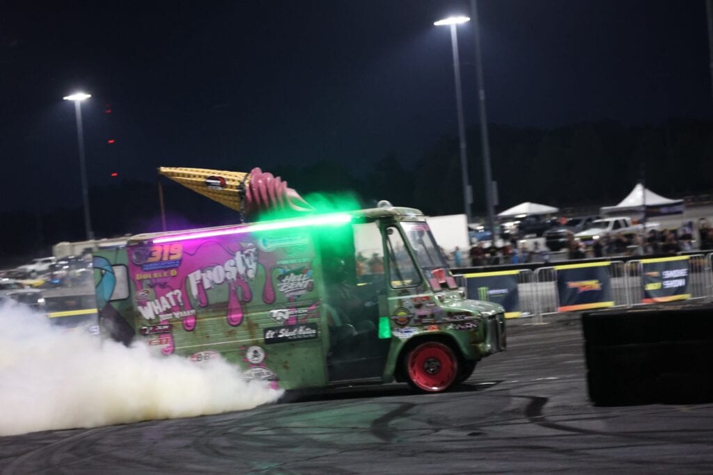 Custom decorated vehicle performing a burnout at Mustang Week event.