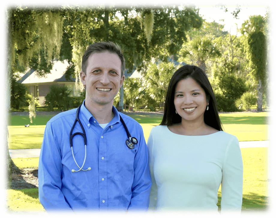 Dr. Kyle Mikals and Dr. Samantha Mikals standing wearing their white coats smiling