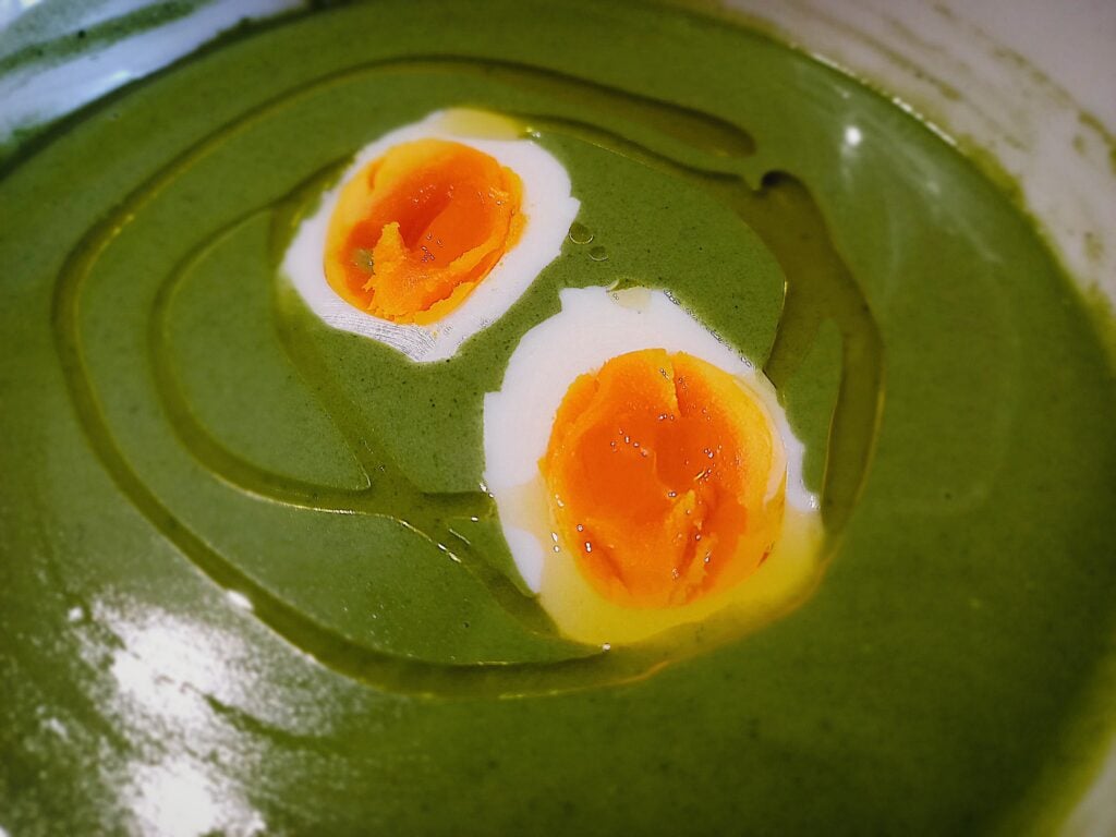 Nettle soup with egg halves on top and drizzle os olive oil