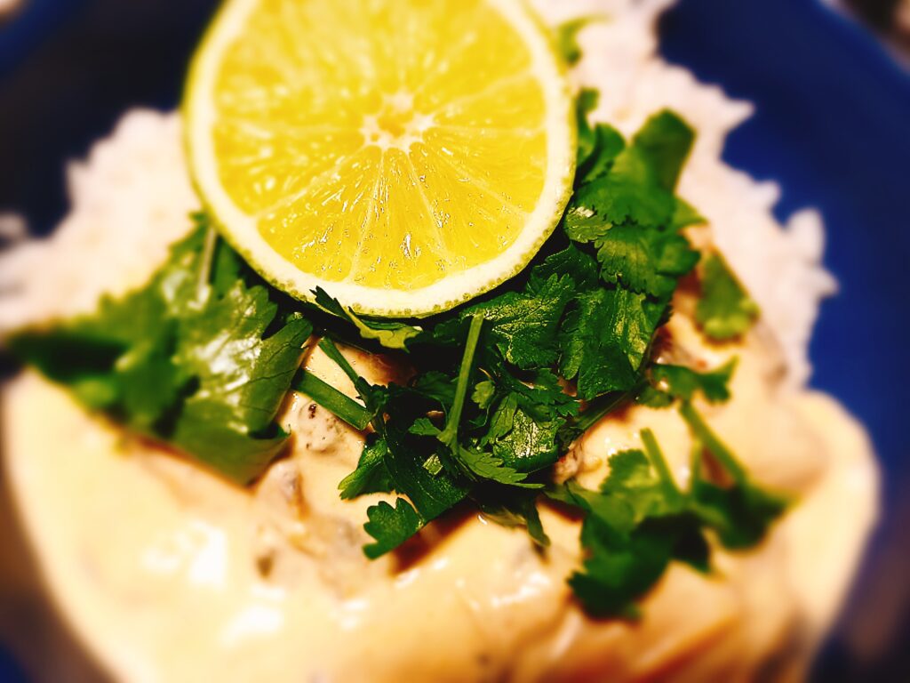 Mussels cooked in curry, coconut cream and lime. Served with rice. Half a lime and chopped coriander on top
