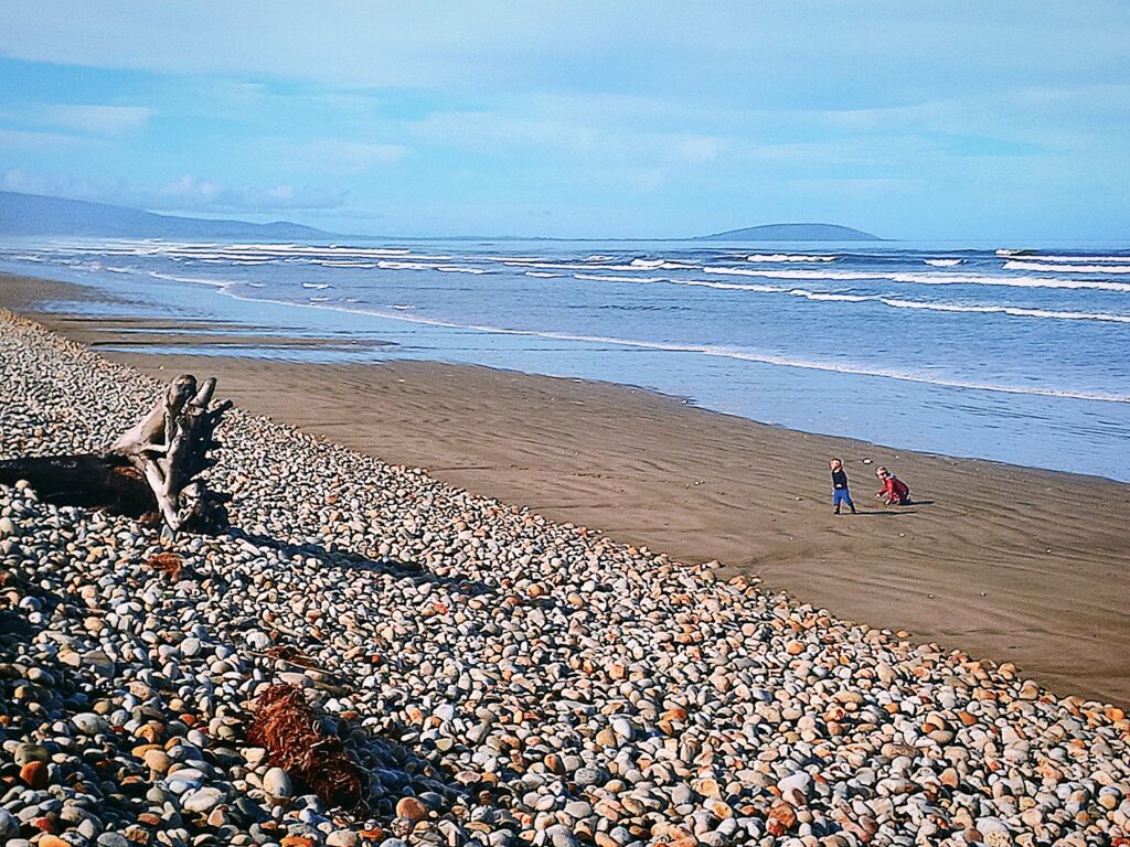 2 kids playing in the distance on a beach