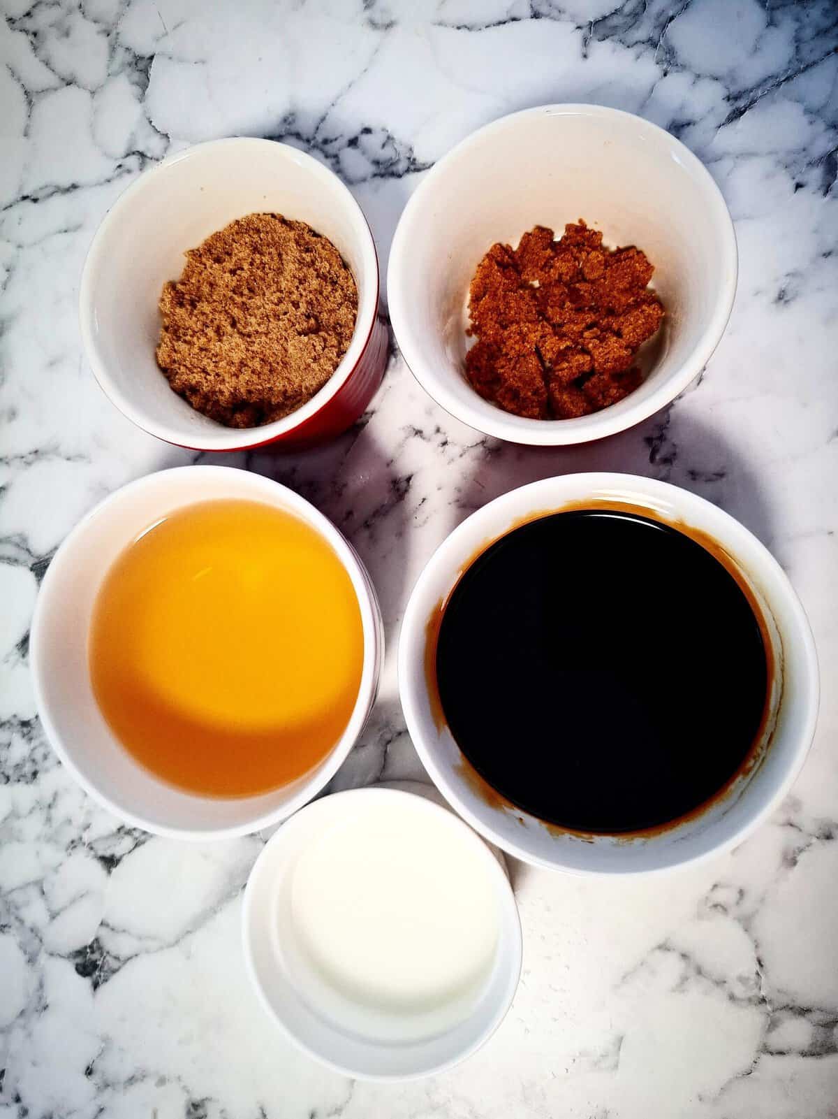 Ingredients for teriyaki sauce in ramekins on a marbled bench top