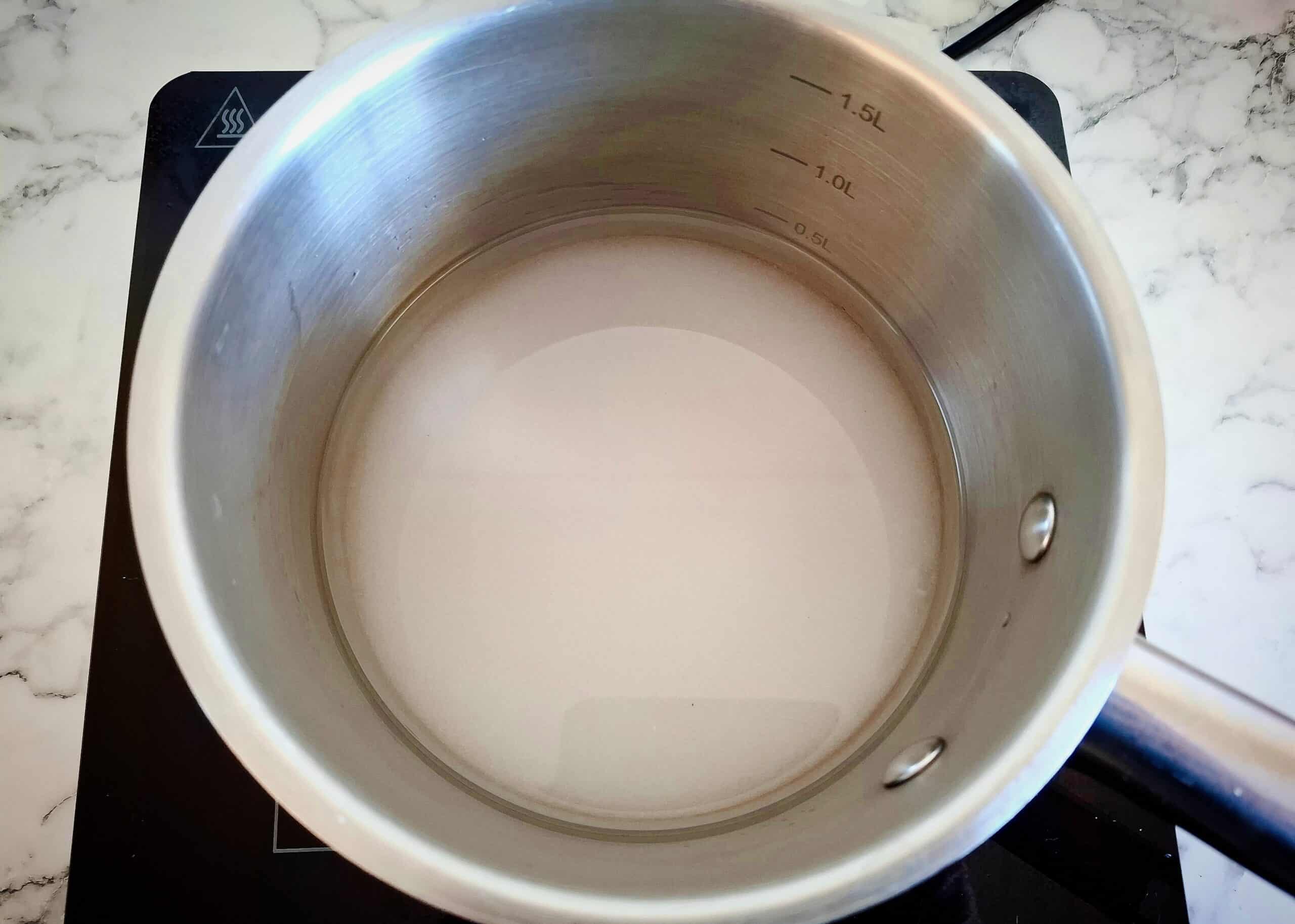 Sugar, water and rice vinegar in a saucepan on the stove.