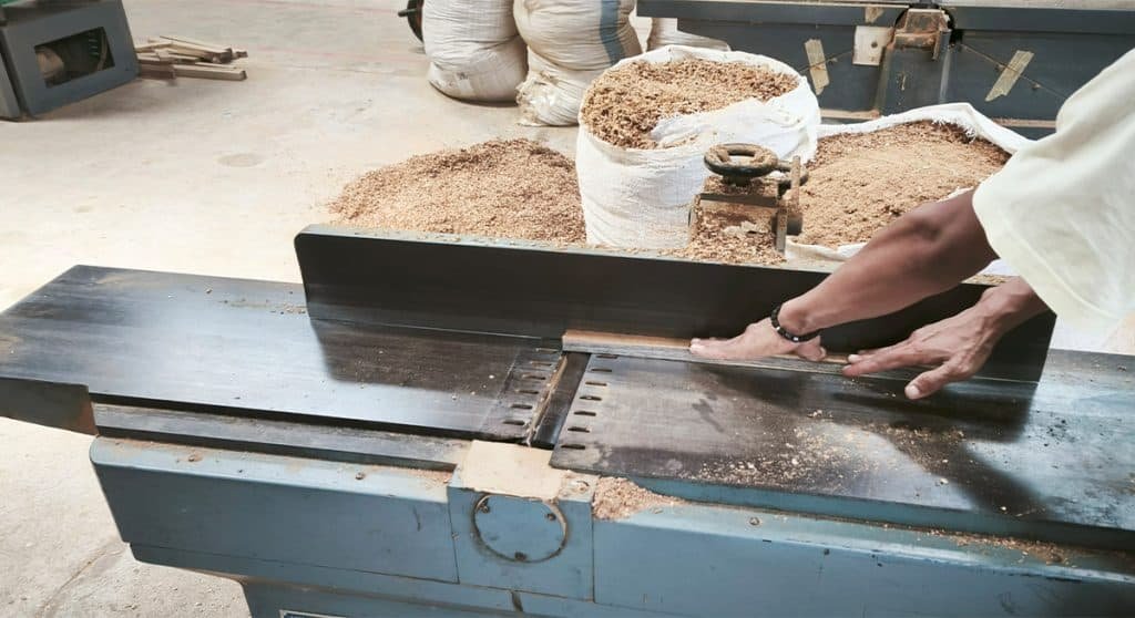 organized Naramulya workshop A Naramulya craftsman using modern furniture manufacturing technology to ensure precision in the production of teak furniture