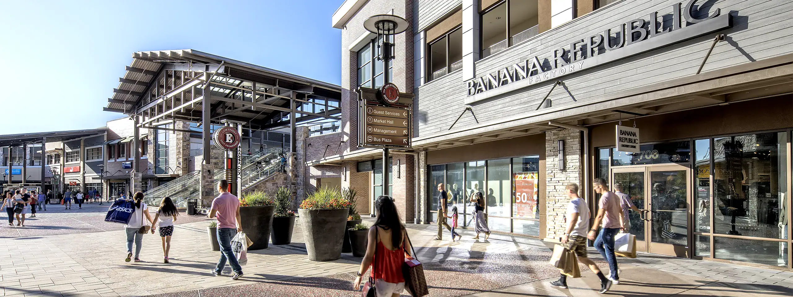 Crowd walking outside a shopping center with Starbucks and Banana Republic stores.