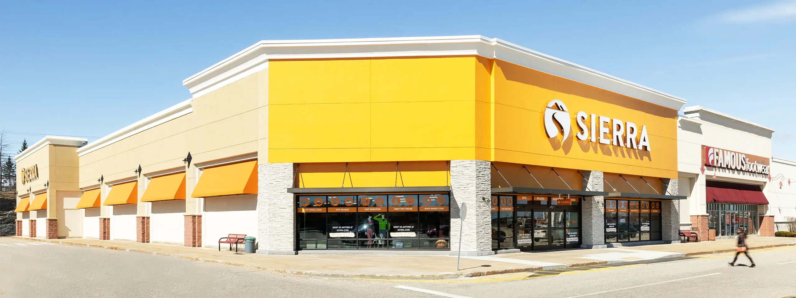 Sierra retail store with yellow facade and large glass windows in a shopping center.