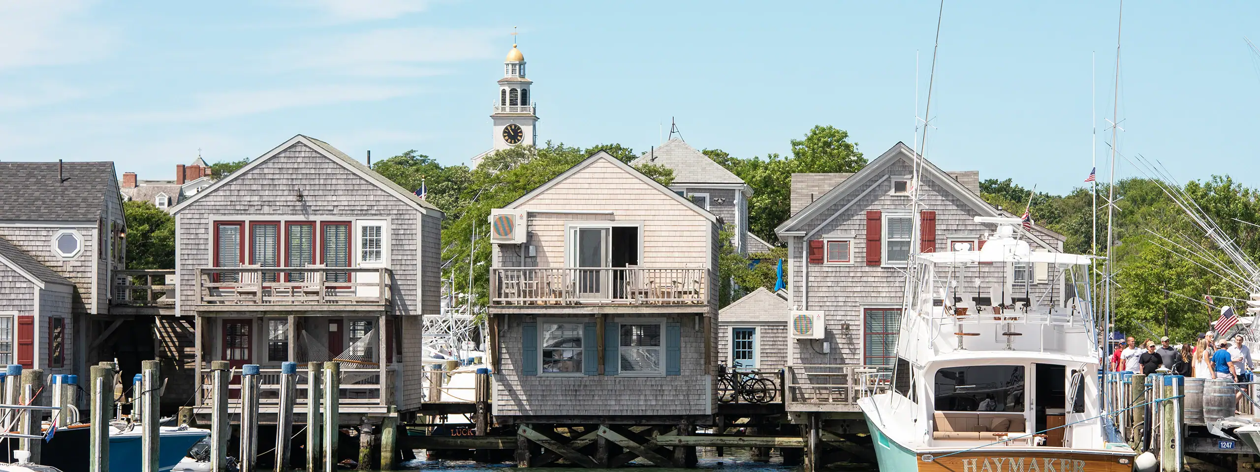 Row of colorful waterfront houses with a boat docked nearby in a coastal town.