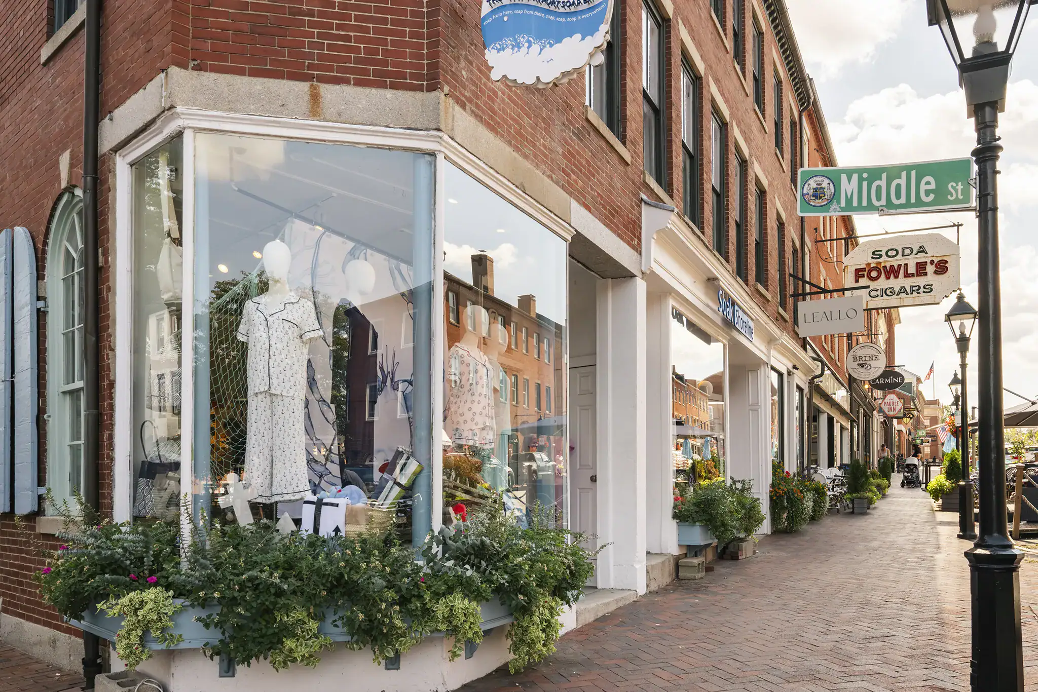 View of a storefront on Middle Street with large display windows and potted plants outside.