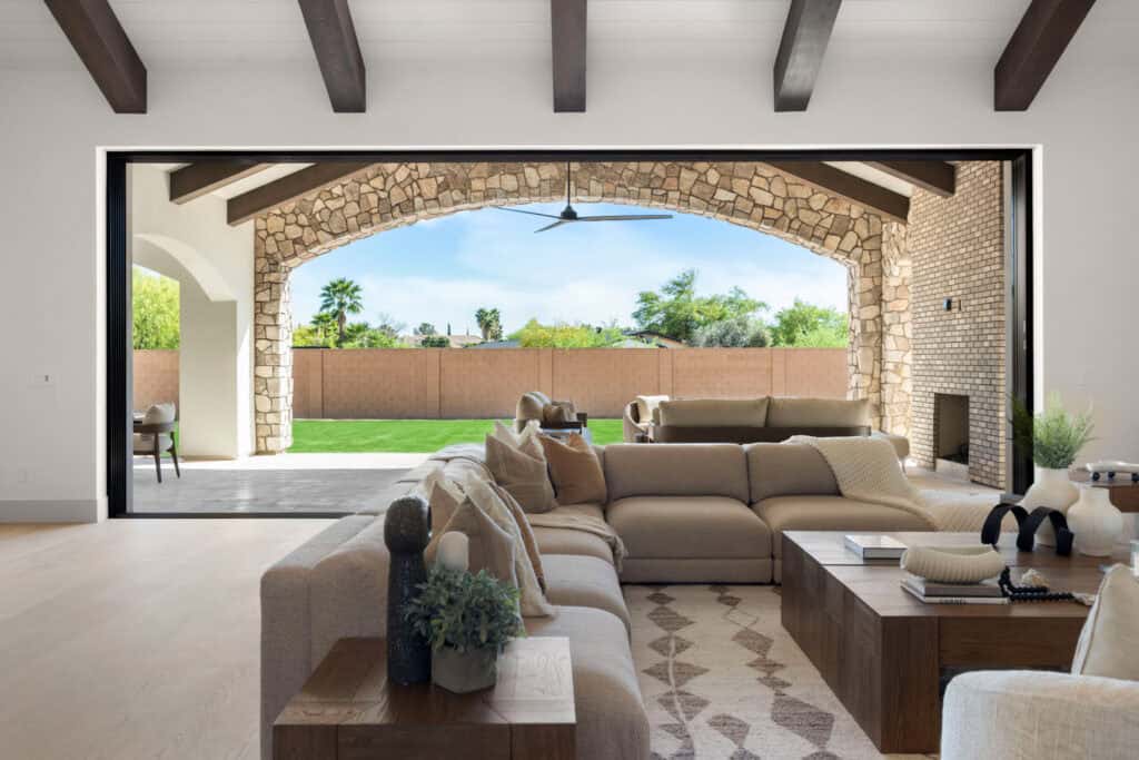 Spacious living room with stone arch opening to backyard and modern furniture.