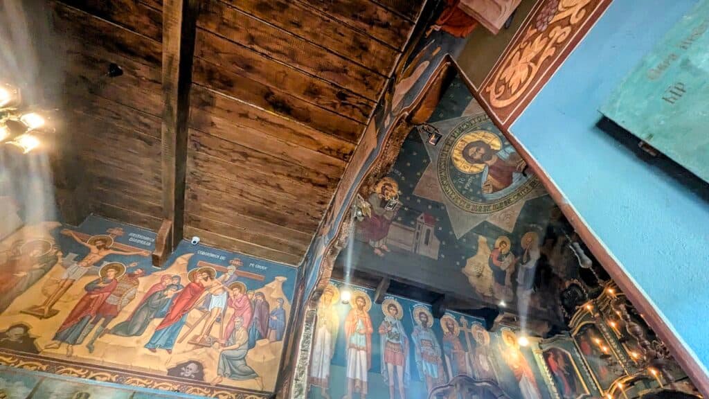 Inside Intercession of Virgin Mary wooden church on the outskirts of Chisinau in the village museum. Brightly coloured paintings from stories of Jesus' life and saints