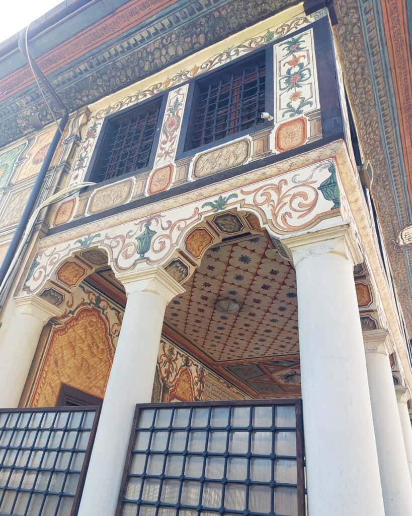 exterior of painted mosque tetovo including the arches of the entranc, painted exterior and portch and upper window. and intricate roof descoration