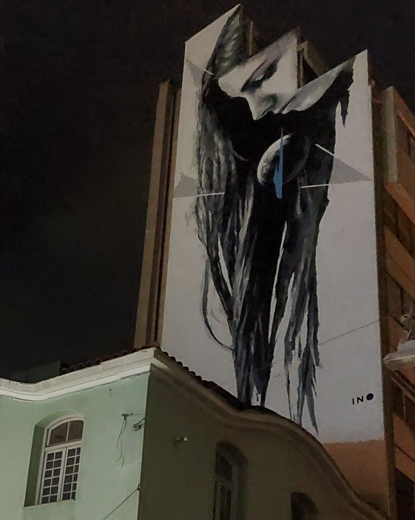 Athens street art lady with long black hair on side of apartment Greece