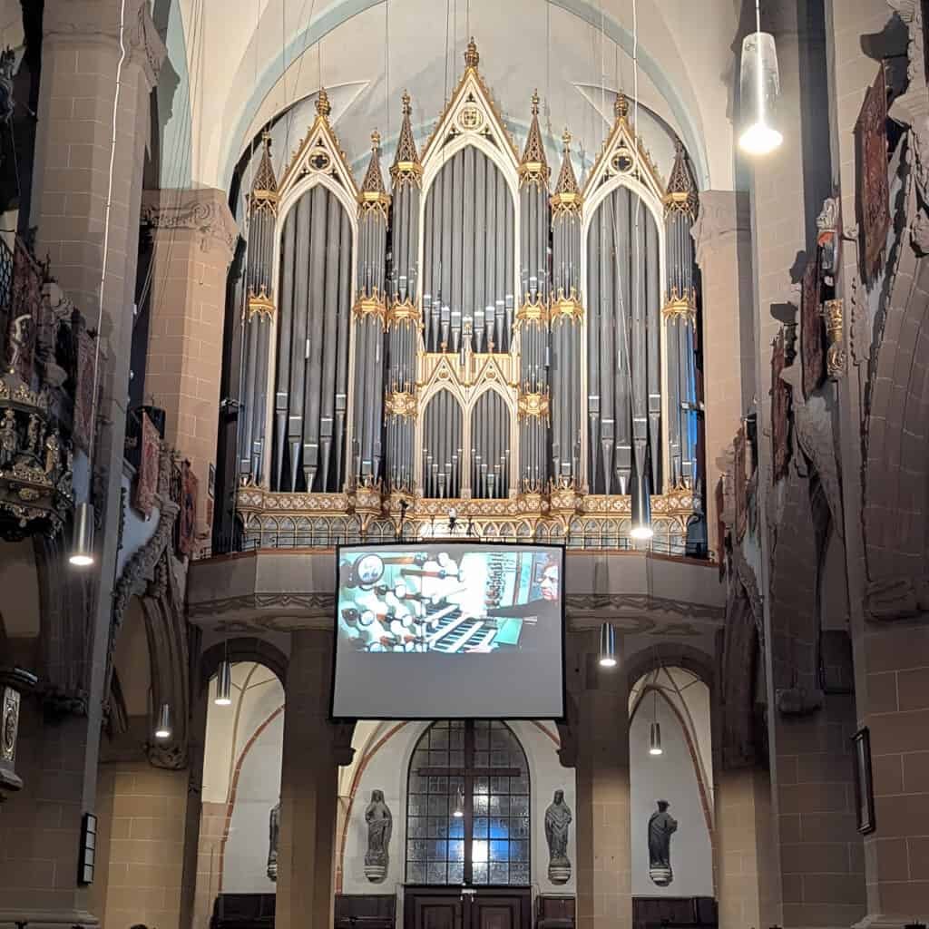 Buchholz organ inside the Black Church, Brasov, Romania during a recital. Screen showing the organist playing - he's on the balcony