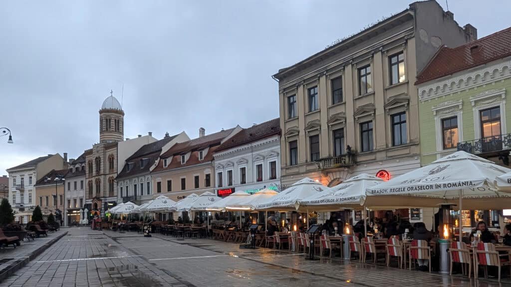 Piața Sfatului, the main square in the historic city of Brașov, Romania. View of Shops and cafes