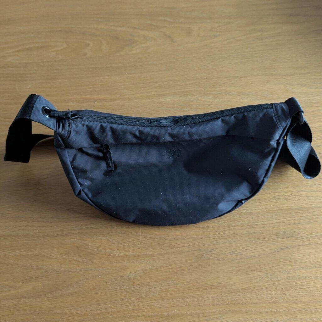 Cabin Zero 5L Moonbag Closed in Absolute Black with toggle on zip passed through eyelet on strap to secure - antitheft features also include RFID pocket - weather resistant - Upgraded version of Uniqlo viral bag