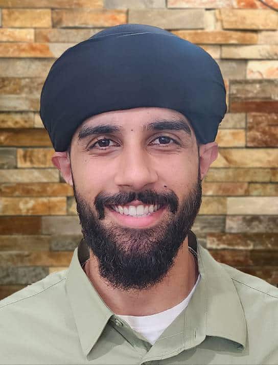 Smiling male dentist with beard and turban in dental office.