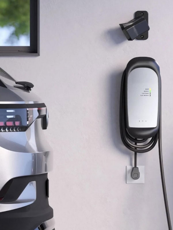 Electric vehicle charging station mounted on a wall next to a car.