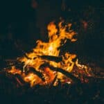 a campfire in full flame for a camp