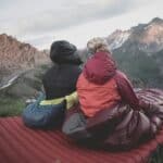 2 people using sleeping bags in a cold climate hike
