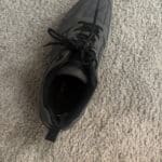 a hiking shoe sitting on carpet floor in home
