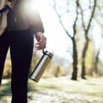 someone carrying water bottle during hike
