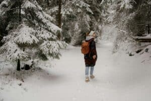 a woman walking in forest during winter