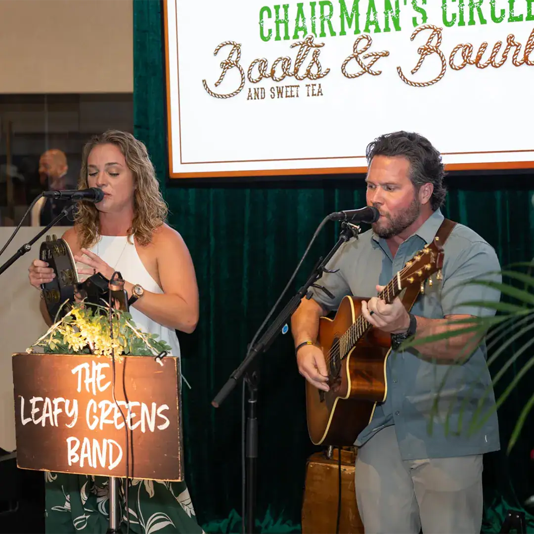 Two performers singing on stage at a concert.
