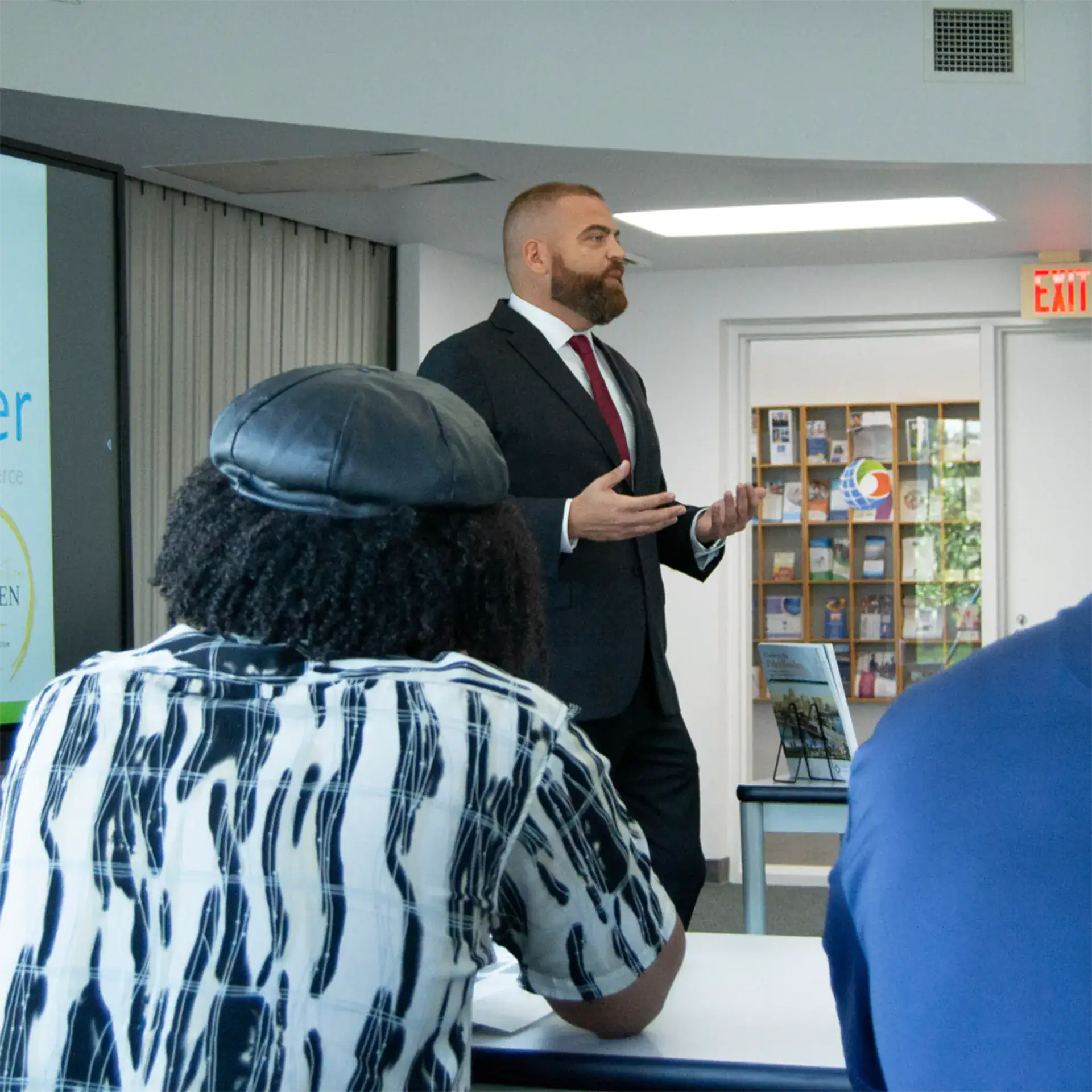 Business professional presenting to a group in a conference room.