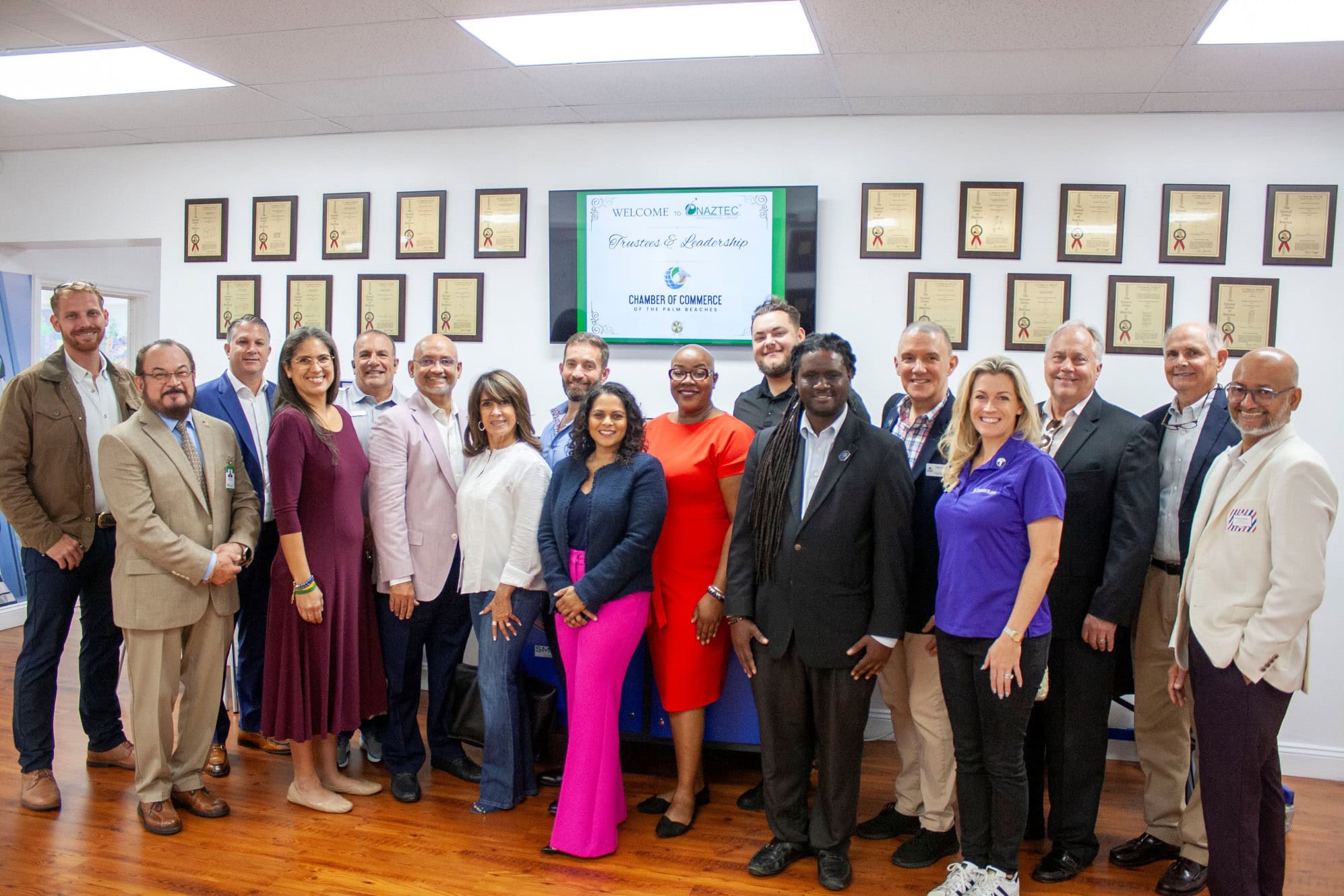 Diverse group of people posing for a photo at a professional event.