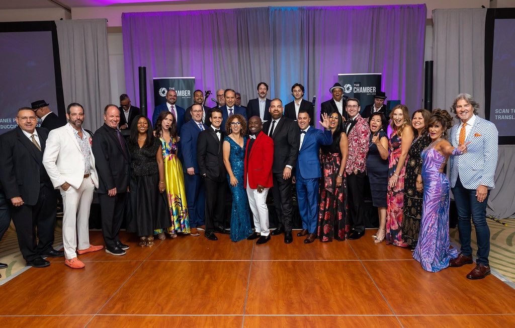 Diverse group of people in formal attire at a professional gathering.
